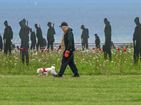 VER-SUR-MER, FRANCE - MAY 26: 
A visitor with a dog discovers 1,475 upcycled giant soldier silhouettes by 'Standing with Giants,' symbolizin...
