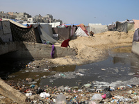 Displaced Palestinians are walking between their tents that they have set up next to the beach, in Deir el-Balah, central Gaza Strip, on May...