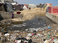 Displaced Palestinians are walking between their tents that they have set up next to the beach, in Deir el-Balah, central Gaza Strip, on May...