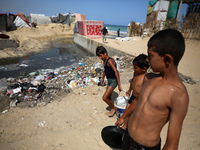 Displaced Palestinians are walking between their tents that they have set up next to the beach, in Deir el-Balah, central Gaza Strip, on May...