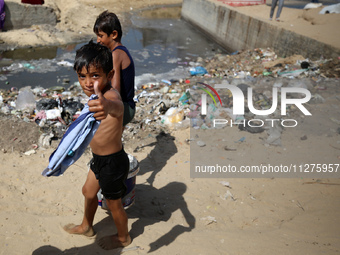 Displaced Palestinians are walking between their tents that they have set up next to the beach, in Deir el-Balah, central Gaza Strip, on May...