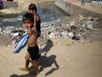 Displaced Palestinians are walking between their tents that they have set up next to the beach, in Deir el-Balah, central Gaza Strip, on May...