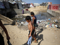 Displaced Palestinians are walking between their tents that they have set up next to the beach, in Deir el-Balah, central Gaza Strip, on May...