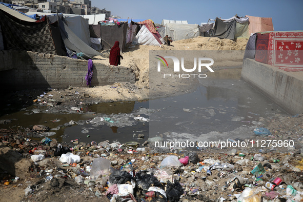 Displaced Palestinians are walking between their tents that they have set up next to the beach, in Deir el-Balah, central Gaza Strip, on May...