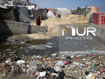 Displaced Palestinians are walking between their tents that they have set up next to the beach, in Deir el-Balah, central Gaza Strip, on May...