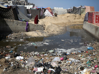 Displaced Palestinians are walking between their tents that they have set up next to the beach, in Deir el-Balah, central Gaza Strip, on May...