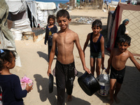 Displaced Palestinians are walking between their tents that they have set up next to the beach, in Deir el-Balah, central Gaza Strip, on May...