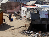 Displaced Palestinians are walking between their tents that they have set up next to the beach, in Deir el-Balah, central Gaza Strip, on May...