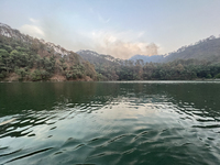 Smoke is rising from forest fires above the mountains surrounding Sattal Lake in Sattal (Sat Tal), Uttarakhand, India, on April 20, 2024. (