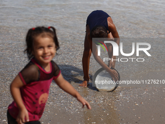 A Palestinian boy is washing kitchenware on the beach in Deir el-Balah, central Gaza Strip, on May 26, 2024, amid the ongoing conflict betwe...