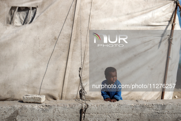 Displaced Palestinians are walking between their tents that they are setting up next to the beach, in Deir el-Balah, central Gaza Strip, on...