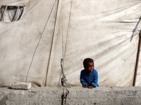 Displaced Palestinians are walking between their tents that they are setting up next to the beach, in Deir el-Balah, central Gaza Strip, on...