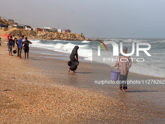 A Palestinian is collecting sea water to wash clothes at the beach in Deir el-Balah, central Gaza Strip, on May 26, 2024, amid the ongoing c...