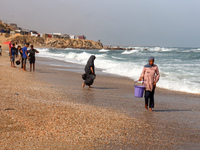 A Palestinian is collecting sea water to wash clothes at the beach in Deir el-Balah, central Gaza Strip, on May 26, 2024, amid the ongoing c...