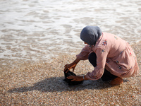 A Palestinian woman is washing clothes at the beach in Deir el-Balah, central Gaza Strip, on May 26, 2024, amid the ongoing conflict between...