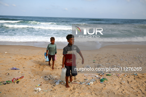 A Palestinian is collecting sea water to wash clothes at the beach in Deir el-Balah, central Gaza Strip, on May 26, 2024, amid the ongoing c...