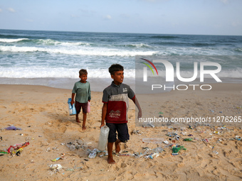 A Palestinian is collecting sea water to wash clothes at the beach in Deir el-Balah, central Gaza Strip, on May 26, 2024, amid the ongoing c...