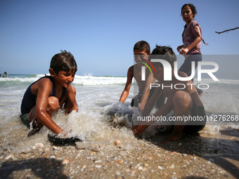 A Palestinian is collecting sea water to wash clothes at the beach in Deir el-Balah, central Gaza Strip, on May 26, 2024, amid the ongoing c...