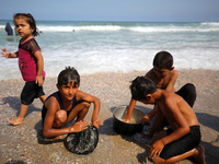 A Palestinian is collecting sea water to wash clothes at the beach in Deir el-Balah, central Gaza Strip, on May 26, 2024, amid the ongoing c...