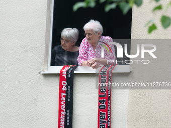 People are showing the Leverkusen football scarf before the Bayer 04 Leverkusen team arrives at Bay Arena Stadium in Leverkusen, Germany, on...