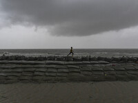 A boy is playing on an embankment in Kuakata, Bangladesh, on May 26, 2024, ahead of cyclone Remal's landfall in Bangladesh. (