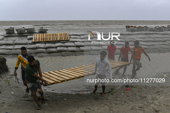 Local people are moving their belongings to another place in Kuakata, Bangladesh, on May 26, 2024, ahead of Cyclone Remal's landfall in Bang...