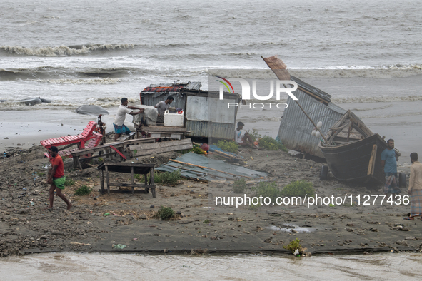 People are moving their goods to a safe place at Kuakata Sea Beach in southern Bangladesh on May 26, 2024, as Cyclone Remal nears. 