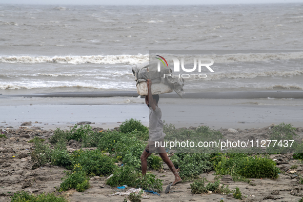 People are moving their goods to a safe place at Kuakata Sea Beach in southern Bangladesh on May 26, 2024, as Cyclone Remal nears. 