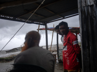 People are taking shelter during a heavy rainfall at Kuakata Sea Beach area in southern Bangladesh on May 26, 2024, as Cyclone Remal nears....
