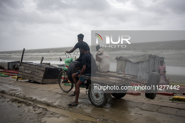 People are moving their goods to a safe place at Kuakata Sea Beach in southern Bangladesh on May 26, 2024, as Cyclone Remal nears. 