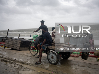 People are moving their goods to a safe place at Kuakata Sea Beach in southern Bangladesh on May 26, 2024, as Cyclone Remal nears. (