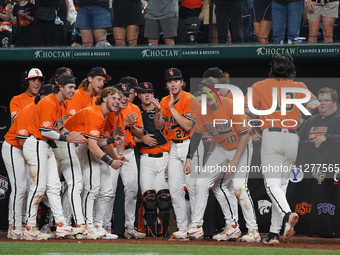 Oklahoma State players are celebrating a score by Kollin Ritchie #13 during the 2024 Big 12 Baseball Championship game between the Oklahoma...