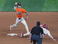 Oklahoma State second baseman Lane Forsythe #6 is trying the double play during the 2024 Big 12 Baseball Championship game between the Oklah...