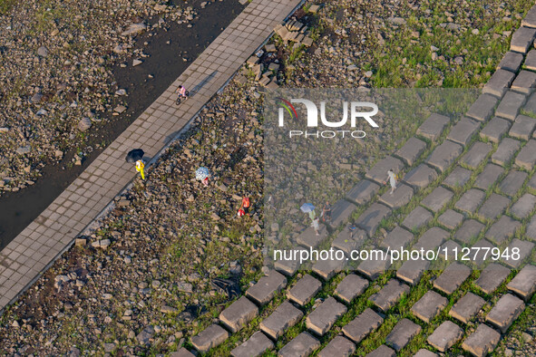 Citizens are playing on the beach of the Jialing River as the water level drops in Chongqing, China, on May 26, 2024. 