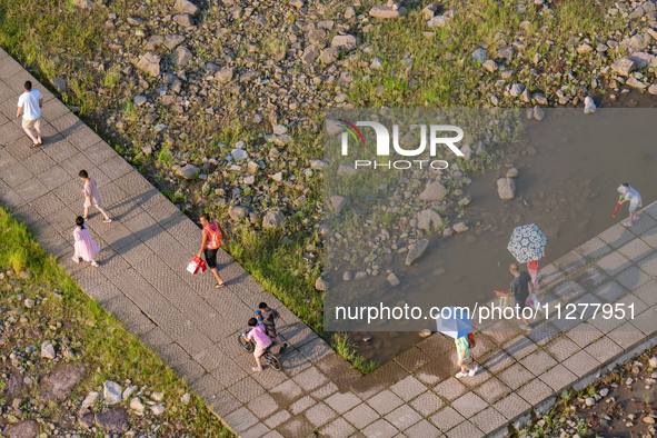 Citizens are playing on the beach of the Jialing River as the water level drops in Chongqing, China, on May 26, 2024. 