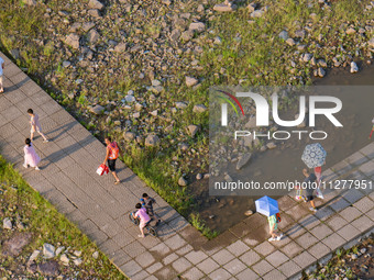 Citizens are playing on the beach of the Jialing River as the water level drops in Chongqing, China, on May 26, 2024. (