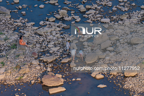 Citizens are playing on the beach of the Jialing River as the water level drops in Chongqing, China, on May 26, 2024. 