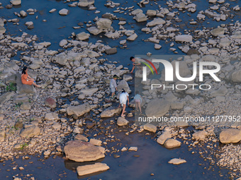 Citizens are playing on the beach of the Jialing River as the water level drops in Chongqing, China, on May 26, 2024. (