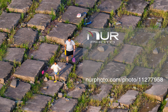 Citizens are playing on the beach of the Jialing River as the water level drops in Chongqing, China, on May 26, 2024. 