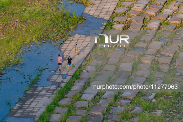 Citizens are playing on the beach of the Jialing River as the water level drops in Chongqing, China, on May 26, 2024. 