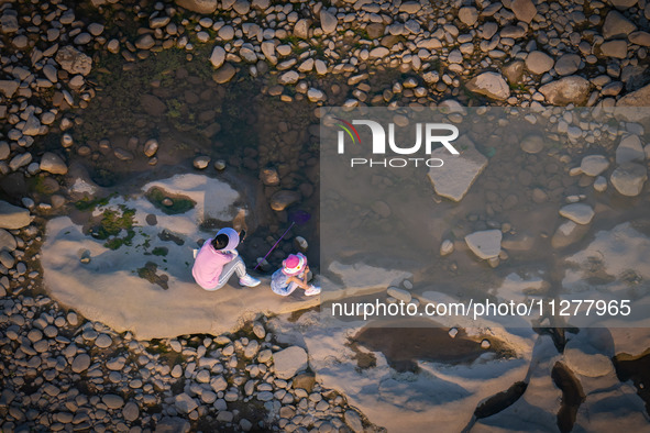 Citizens are playing on the beach of the Jialing River as the water level drops in Chongqing, China, on May 26, 2024. 