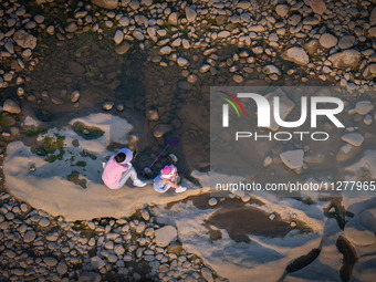 Citizens are playing on the beach of the Jialing River as the water level drops in Chongqing, China, on May 26, 2024. (