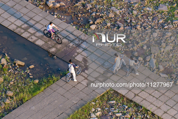 Citizens are playing on the beach of the Jialing River as the water level drops in Chongqing, China, on May 26, 2024. 