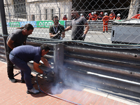 Workers repair barrier after Sergio Perez of Red Bull Racing and Kevin Magnussen of Haas crash during the Formula 1 Grand Prix of Monaco at...