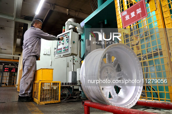 A worker is producing a wheel hub at a workshop of an automobile wheel manufacturer in Binzhou, China, on May 27, 2024. 