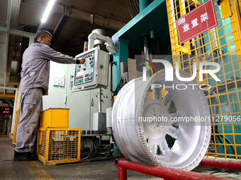 A worker is producing a wheel hub at a workshop of an automobile wheel manufacturer in Binzhou, China, on May 27, 2024. (