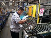 A worker is producing a wheel hub at a workshop of an automobile wheel manufacturer in Binzhou, China, on May 27, 2024. (