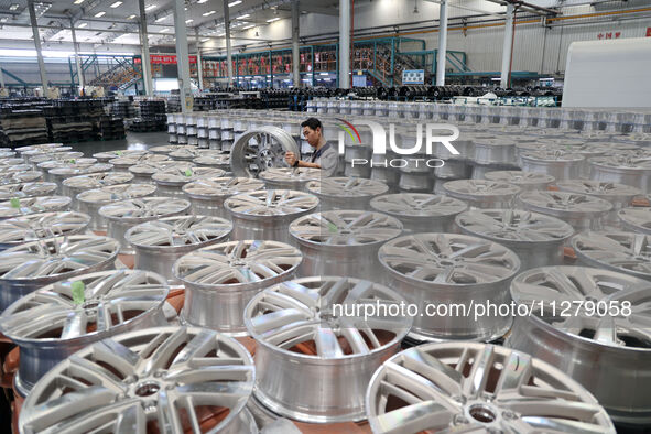 A worker is producing a wheel hub at a workshop of an automobile wheel manufacturer in Binzhou, China, on May 27, 2024. 