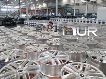 A worker is producing a wheel hub at a workshop of an automobile wheel manufacturer in Binzhou, China, on May 27, 2024. (