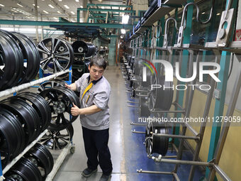 A worker is producing a wheel hub at a workshop of an automobile wheel manufacturer in Binzhou, China, on May 27, 2024. (